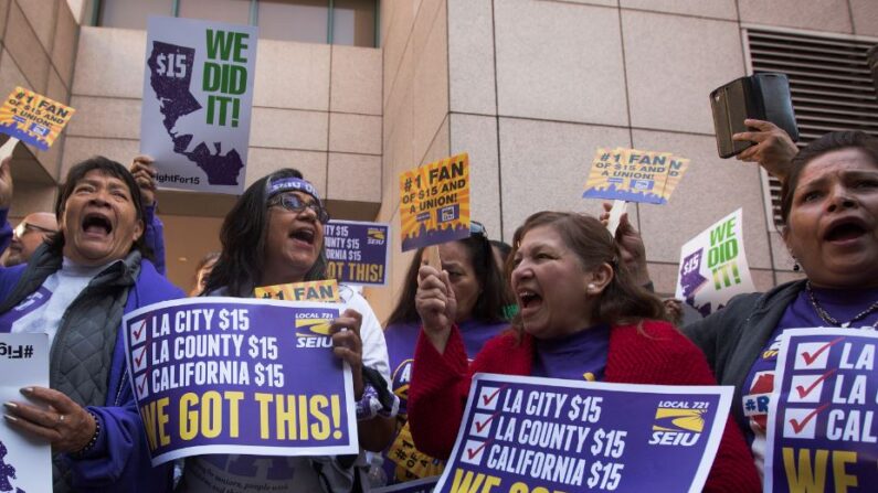 Miembros del Sindicato Internacional de Empleados de Servicio celebran después de que el gobernador de California, Jerry Brown, promulgara la histórica legislación SB 3 en Los Ángeles, California, el 4 de abril de 2016 (David McNew / Getty Images).