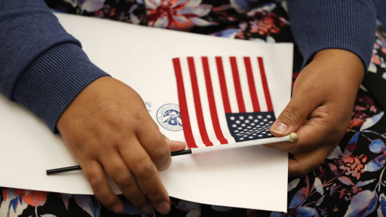 Una persona sostiene una bandera estadounidense en una ceremonia de naturalización del Servicio de Ciudadanía e Inmigración de Estados Unidos en Miami, Florida, el 17 de agosto de 2018. (Joe Raedle/Getty Images)