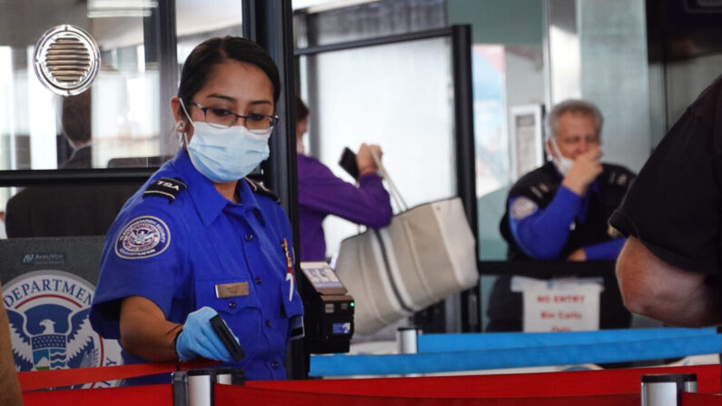 Trabajadores de la Administración de Seguridad del Transporte (TSA) revisan a los pasajeros en el Aeropuerto Internacional O'Hare en Chicago, Illinois, el 8 de noviembre de 2021. (Scott Olson/Getty Images)