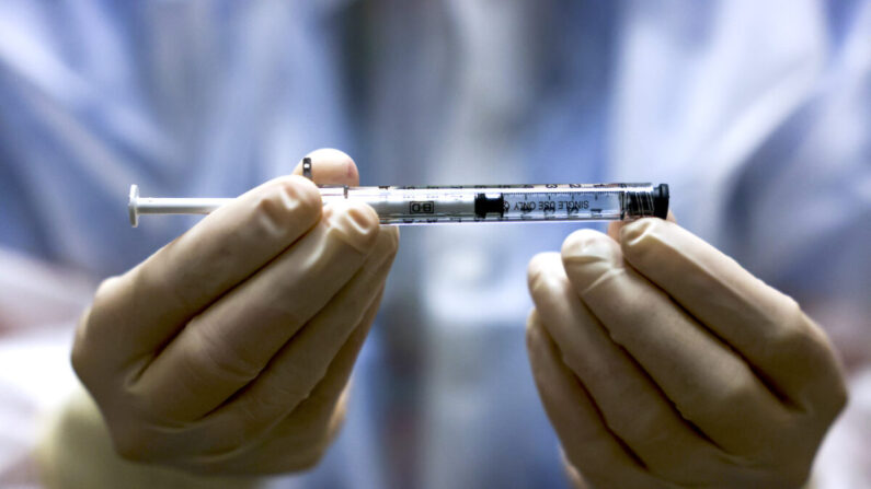 Una persona sostiene una dosis de la vacuna COVID-19. (Michael Ciaglo/Getty Images)