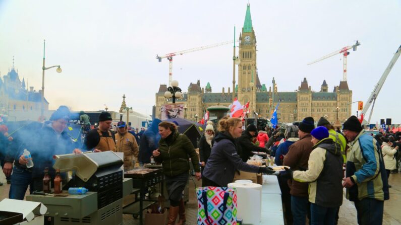 Voluntarios sirven comida y bebida a los manifestantes que se oponen a los mandatos y restricciones por el COVID-19 en Ottawa el 9 de febrero de 2022. (Jonathan Ren/The Epoch Times)