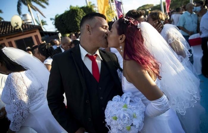 Una pareja festeja con un beso luego de participar en la celebración de una boda masiva el día de San Valentín, en Managua, Nicaragua. (EFE/ Jorge Torres)