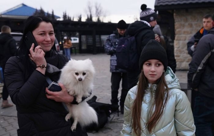 Una mujer sostiene a su perro mientras habla por teléfono, tras cruzar de Ucrania a Rumanía, el 24 de febrero de 2022 en Sighetu Marmatiei, Rumanía. (Andreea Campeanu/Getty Images)