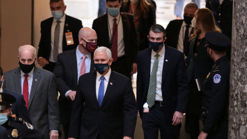 El vicepresidente de Estados Unidos, Mike Pence, (C), camina por el Statuary Hall del Capitolio de Estados Unidos en dirección a la Cámara de Representantes en el Capitolio de Estados Unidos el 6 de enero de 2021 en Washington, DC. (Cheriss May/Getty Images)