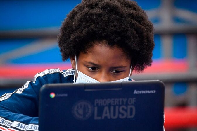 Un niño lleva una mascarilla mientras asiste a una clase online en un centro de aprendizaje dentro del Crenshaw Family YMCA durante la pandemia de COVID-19 el 17 de febrero de 2021 en Los Ángeles, California. (PATRICK T. FALLON/AFP vía Getty Images)