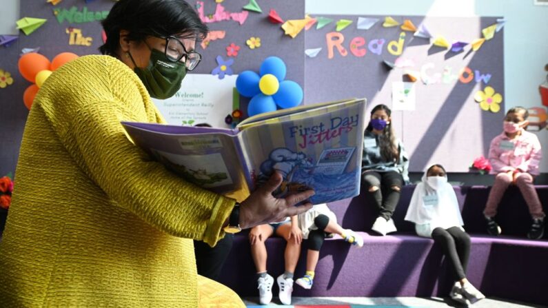 La superintendente interina del Distrito Escolar Unificado de Los Ángeles (LAUSD), Megan Reilly, lee un libro llamado "First Day Jitters" a los estudiantes en la biblioteca de la Escuela Primaria Kim en el primer día del año escolar, en Los Ángeles, California, el 16 de agosto de 2021. (ROBYN BECK/AFP vía Getty Images)