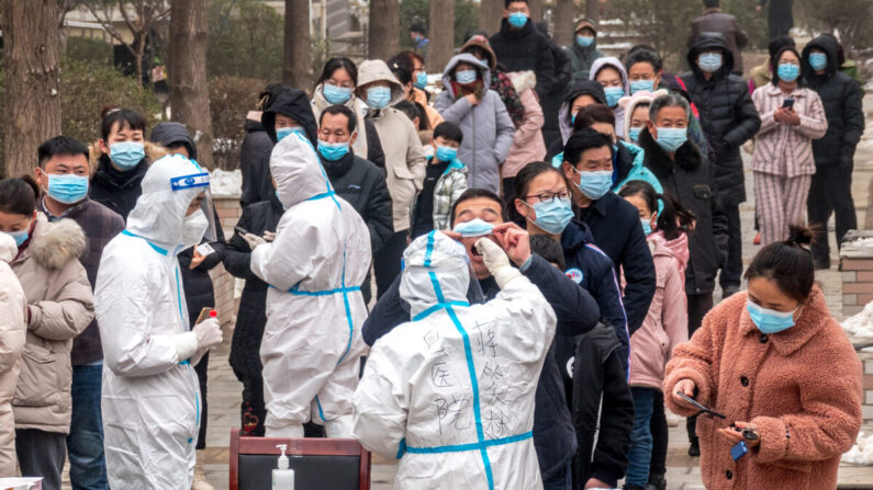 Los residentes hacen fila para someterse a las pruebas de ácido nucleico de COVID-19 en Anyang, en la provincia central china de Henan, el 26 de enero de 2022. (STR/AFP vía Getty Images)