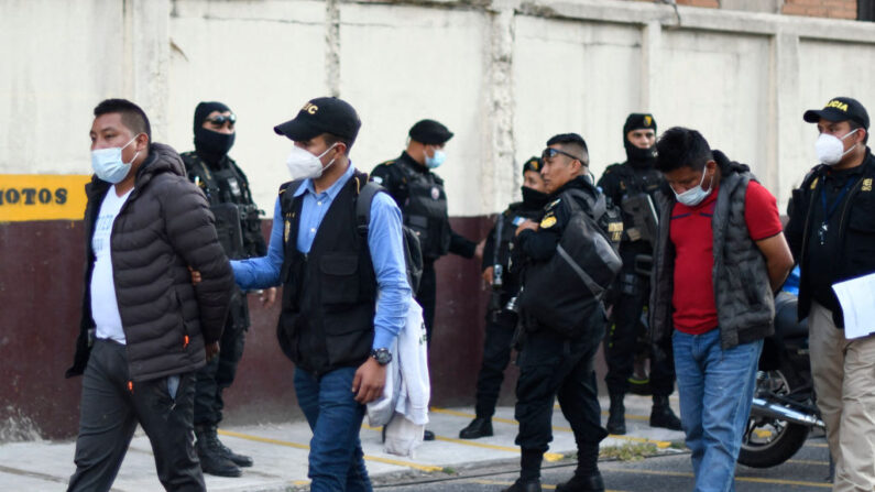 Juan Miranda (izq.) y Efraín Miranda (der.) son vistos tras ser detenidos por ser presuntos miembros de una red de trata de personas, a las afueras del Palacio de Justicia en Ciudad de Guatemala, el 28 de enero de 2022.   (JOHAN ORDONEZ/AFP vía Getty Images)