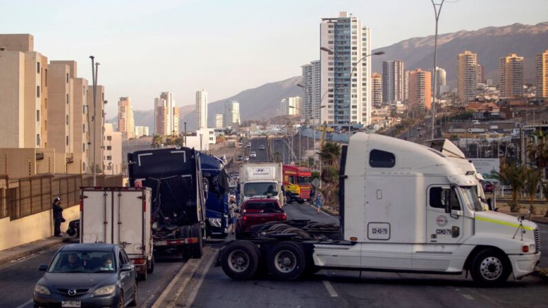 Vehículos se alinean mientras una ruta de acceso a Iquique, Chile, permanece bloqueada durante una huelga regional convocada por diferentes organizaciones contra la inmigración ilegal, el 31 de enero de 2022. (DIEGO REYES/AFP vía Getty Images)