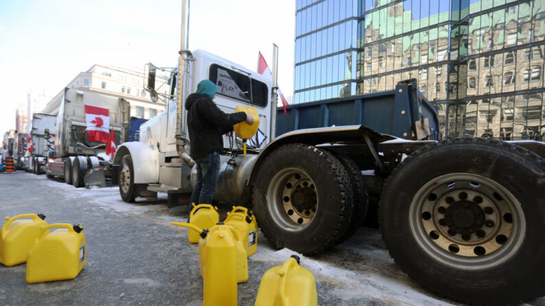 Un camionero recarga combustible mientras los manifestantes continúan protestando por las órdenes de vacunación implementados por el primer ministro Justin Trudeau el 7 de febrero de 2022 en Ottawa, Canadá.  (Dave Chan/AFP vía Getty Images)