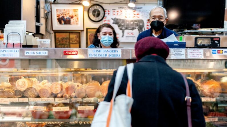 Empleados atienden a cliente en Canales Quality Meats en Eastern Market en Washington, DC, el 8 de febrero de 2022. (STEFANI REYNOLDS/AFP via Getty Images)