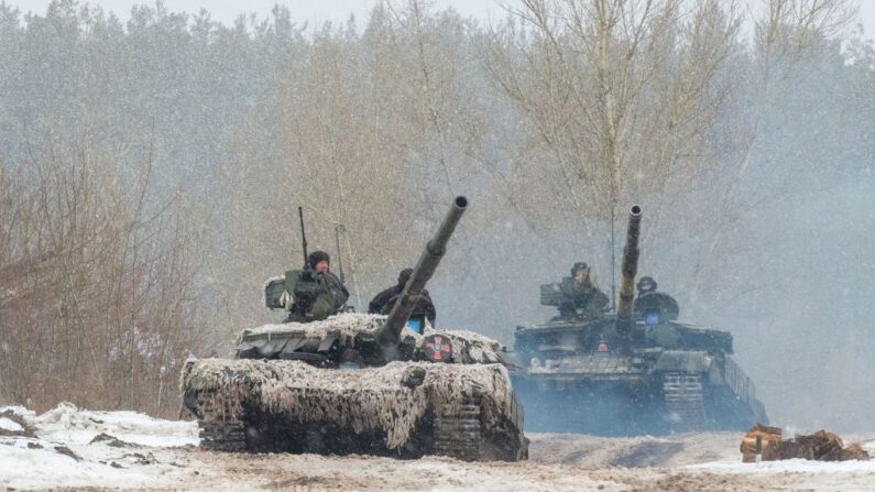 Militares de las Fuerzas Militares de Ucrania de la 92ª brigada mecanizada utilizan tanques, cañones autopropulsados y otros vehículos blindados para realizar ejercicios con fuego real cerca de la ciudad de Chuguev, en la región de Kharkiv, el 10 de febrero de 2022. (Sergey Bobok/AFP vía Getty Images)
