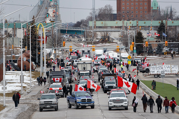 Manifestantes y simpatizantes se instalan en un bloqueo al pie del puente Ambassador, impidiendo el flujo de tránsito comercial sobre el puente hacia Canadá desde Detroit, en Windsor, Ontario, el 10 de febrero de 2022. (Cole Burston/Getty Images)