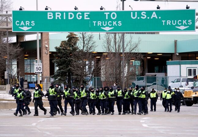 La policía canadiense se despliega el 12 de febrero de 2022 para desalojar a los manifestantes que bloquean el acceso al puente Ambassador exigiendo el fin de los mandatos del gobierno relacionados con el COIVD-19, en Windsor, Ontario. (GEOFF ROBINS/AFP vía Getty Images)