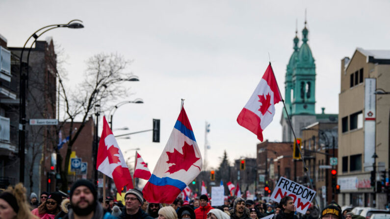 Manifestantes marchan para apoyar al convoy de camioneros que protestan por los mandatos de COVID-19, en Montreal el 12 de febrero de 2022. (Andrej Ivanov/AFP vía Getty Images)