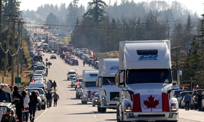 Camiones y otros vehículos circulan por la autopista 15 cerca del cruce fronterizo de la autopista del Pacífico en Surrey, B.C., como parte de un convoy de protesta contra los mandatos y restricciones de la COVID-19, el 12 de febrero de 2022. (Jason Redmon/AFP a través de Getty Images)