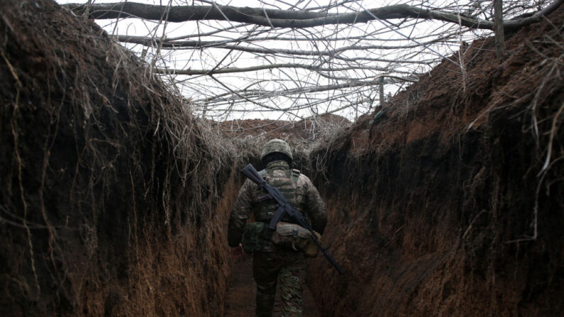 Un militar de las Fuerzas Militares de Ucrania camina a lo largo de una trinchera en el frente con los separatistas respaldados por Rusia, no lejos de Novolugansk, región de Donetsk, el 16 de febrero de 2022. (ANATOLII STEPANOV/AFP a través de Getty Images)