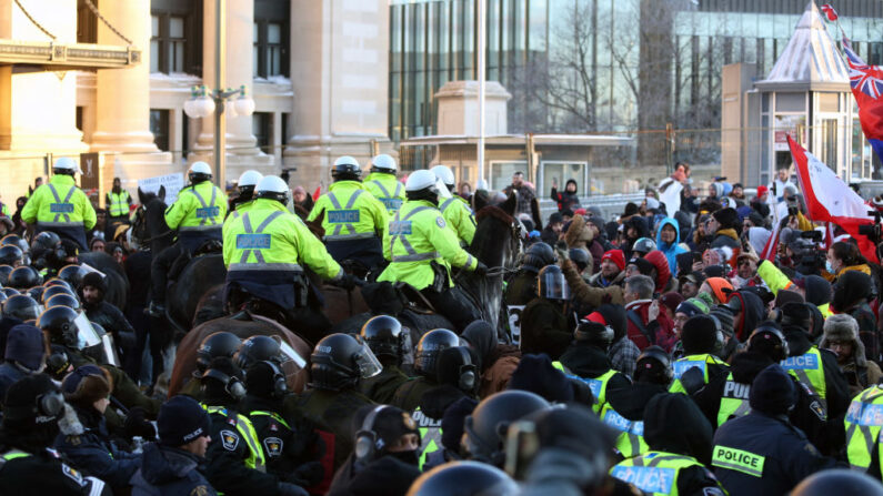 Una unidad de caballos de la policía montada hace retroceder a los manifestantes durante una protesta contra los mandatos relacionados con el COVID-19 en Ottawa, Canadá, el 18 de febrero de 2022.(DAVE CHAN/AFP vía Getty Images)