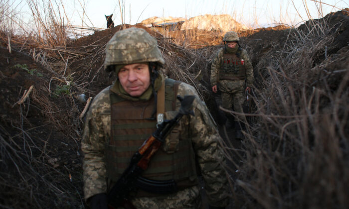 Fuerzas militares ucranianas caminan por las trincheras en su posición en la línea de frente con los separatistas apoyados por Rusia, cerca de la aldea de Novognativka, en la región de Donetsk de Ucrania, el 21 de febrero de 2022. (AnatoliI Stepanov/AFP a través de Getty Images)