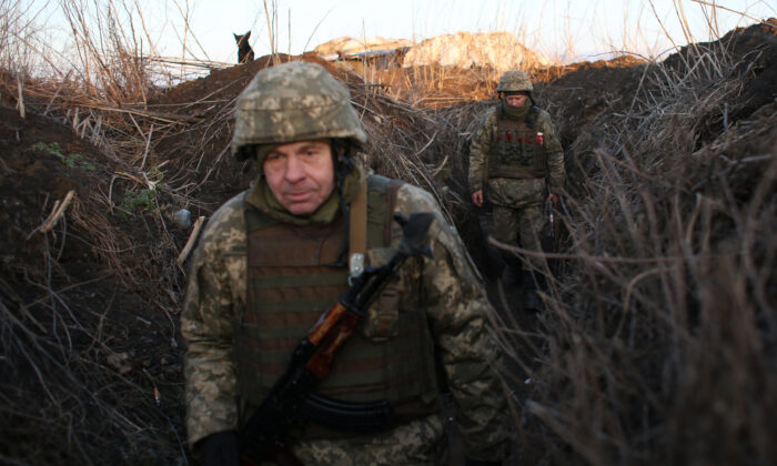 Fuerzas militares de Ucrania caminan a lo largo de las trincheras en el frente ante los separatistas respaldados por Rusia, cerca de la aldea de Novognativka, región de Donetsk, el 21 de febrero de 2022. (Anatoli Stepanov/AFP a través de Getty Images)
