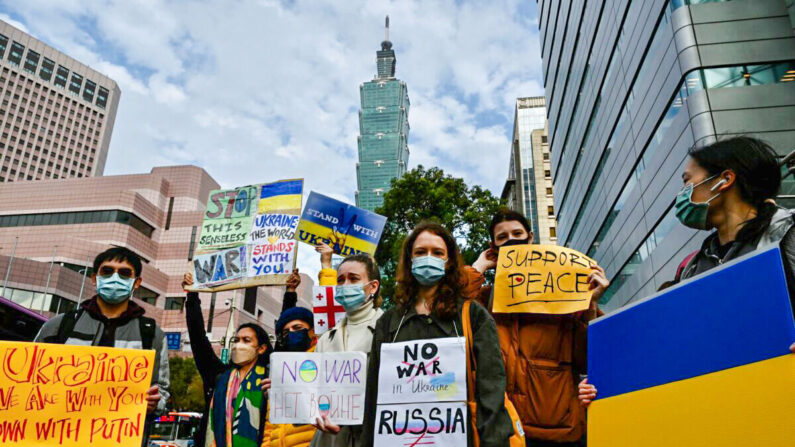 Un grupo de eslavos que viven en Taiwán muestran pancartas para protestar contra la invasión militar rusa de Ucrania, en Taipéi el 25 de febrero de 2022. (Sam Yeh/AFP vía Getty Images)