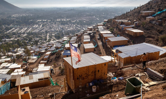 La bandera chilena ondea sobre un campamento de ocupantes ilegales construido por inmigrantes haitianos y peruanos, en Lampa, Chile, el 21 de noviembre de 2021. (John Moore/Getty Images)