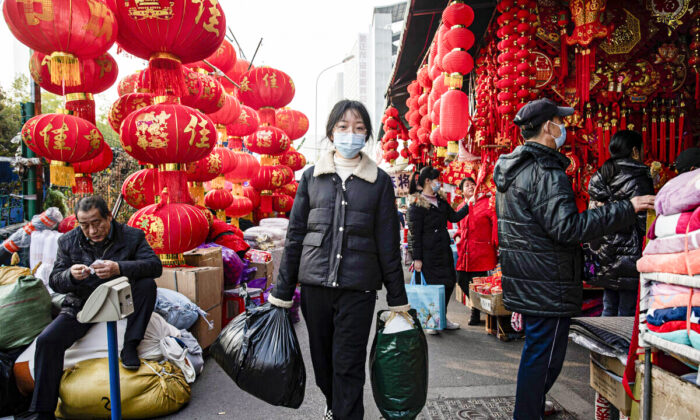 Transeúntes con mascarillas mientras caminan rodeados de faroles en la calle, el 19 de enero de 2022, en Wuhan, provincia de Hubei, China. (Getty Images)
