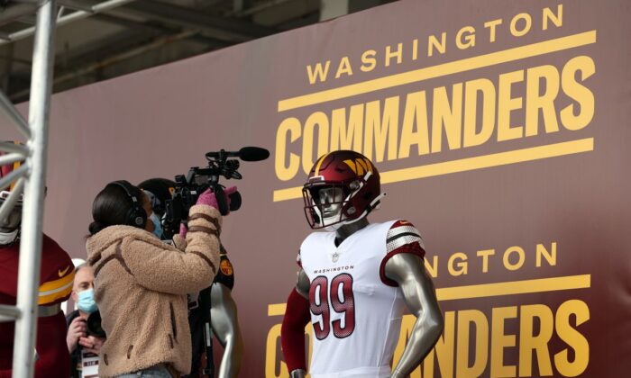 Medios de comunicación toman fotos y videos de los nuevos uniformes durante el anuncio del cambio de nombre del equipo de fútbol de Washington a Washington Commanders, en el FedExField, en Landover, Maryland, el 2 de febrero de 2022. (Rob Carr/Getty Images)
