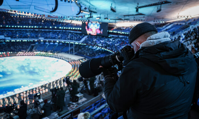 Un integrante de los medios toma una foto de la actuación previa a la ceremonia de los Juegos Olímpicos de Invierno de 2022, el 4 de febrero de 2022, en Beijing, China. (Annice Lyn/Getty Images)
