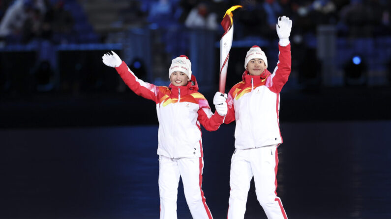 Los atletas chinos Dinigeer Yilamujian y Zhao Jiawen sostienen la llama olímpica durante la ceremonia de apertura de los Juegos Olímpicos de Invierno de 2022 en el Estadio Nacional de Beijing, China, el 4 de febrero de 2022. (Lintao Zhang/Getty Images)