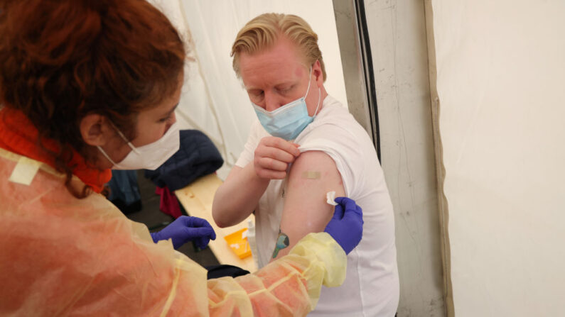 Una trabajadora de la salud administra una dosis de refuerzo de la vacuna Moderna contra el COVID-19 en un centro de vacunación recién inaugurado durante la ola de ómicron el 10 de febrero de 2022 en Berlín, Alemania. (Sean Gallup/Getty Images)