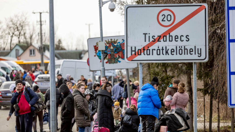 TISZABECS, HUNGRÍA - 25 DE FEBRERO: Personas esperan con sus pertenencias en el paso fronterizo de Tiszabecs-Tiszaujlak mientras huyen de Ucrania el 25 de febrero de 2022 en Tiszabecs, Hungría. (Janos Kummer/Getty Images)