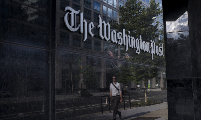 Un hombre pasa frente a The Washington Post, en Washington el 5 de agosto de 2013. (Brendan Smialowski/AFP a través de Getty Images)