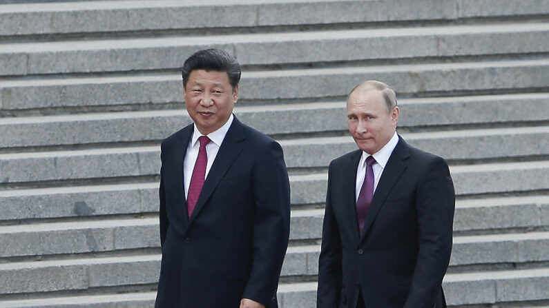 El presidente chino Xi Jinping (izq.) acompaña al presidente ruso Vladimir Putin (der.) en una ceremonia de bienvenida frente al Gran Salón del Pueblo el 25 de junio de 2016 en Beijing, China. (Lintao Zhang/Getty Images)