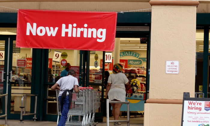Un letrero de "Ahora se contrata" cuelga cerca de la entrada de un supermercado Winn-Dixie en Hallandale (Florida) el 21 de septiembre de 2021. (Joe Raedle/Getty Images)