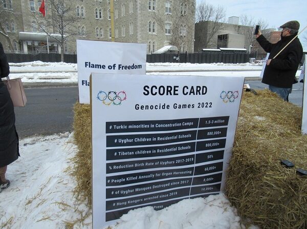 Una tarjeta de puntuación que lleva la cuenta de los crímenes contra la humanidad cometidos por el régimen chino se ve durante la protesta de los "Juegos del Genocidio" frente a la embajada china en Ottawa el 4 de febrero de 2022. (Donna Ho/The Epoch Times)