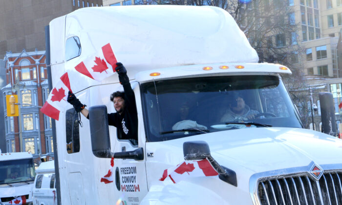 Un hombre ondea banderas canadienses desde un camión en el centro de Ottawa el 29 de enero de 2022. (Noé Chartier/The Epoch Times)