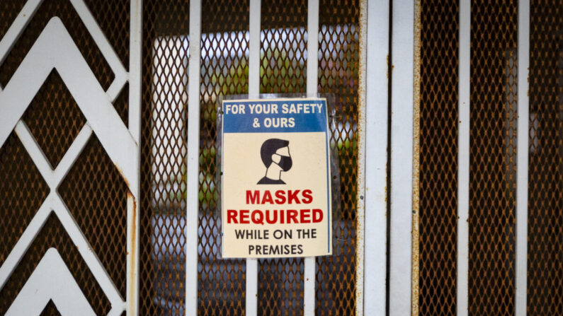 Un cartel solicitando mascarillas cuelga en una puerta en Tustin, California, el 10 de marzo de 2021. (John Fredricks/The Epoch Times)