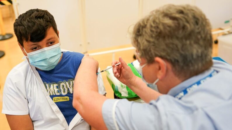 Felix Dima, de 13 años, de Newcastle, recibe la vacuna COVID-19 de Pfizer-BioNTech en la Academia Excelsior de Newcastle upon Tyne, Inglaterra, el 22 de septiembre de 2021. (Ian Forsyth/Getty Images)
