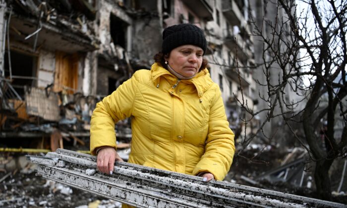 Una mujer limpia los escombros de un edificio residencial dañado en la calle Koshytsa, un suburbio de la capital ucraniana, Kiev, donde supuestamente cayó un proyectil militar el 25 de febrero de 2022. (Daniel Leal/AFP vía Getty Images)