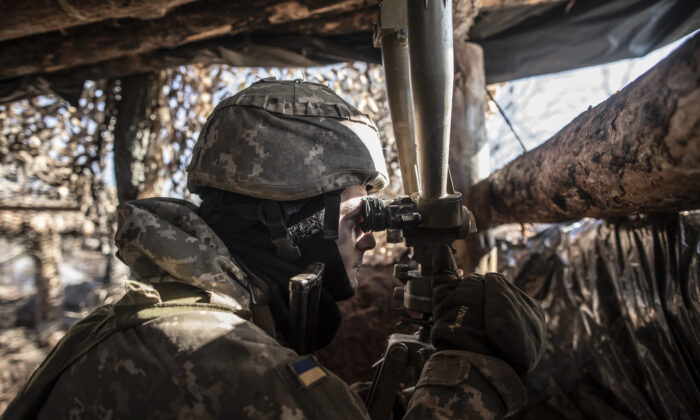 Un militar ucraniano vigila las posiciones separatistas prorrusas desde una trinchera en la línea de contacto cerca del pueblo de Svitlodarsk, en la región de Donestsk en Svitlodarsk, Ucrania, el 14 de febrero de 2022. (Manu Brabo/Getty Images)