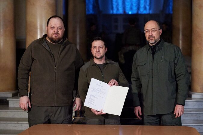 Una foto facilitada por el canal oficial de Telegram del presidente de Ucrania Volodymyr Zelenskyi muestra al presidente ucraniano Volodymyr Zelensky (C) posando con el primer ministro Denys Shmyhal (D), el presidente del Parlamento, Ruslan Stefanchuk (I) y una carta en la que se lee una solicitud firmada para la adhesión de Ucrania a la Unión Europea, en un lugar no revelado de Ucrania, el 28 de febrero de 2022. (EFE/EPA/TELEGRAM/V_Zelenskiy_official)