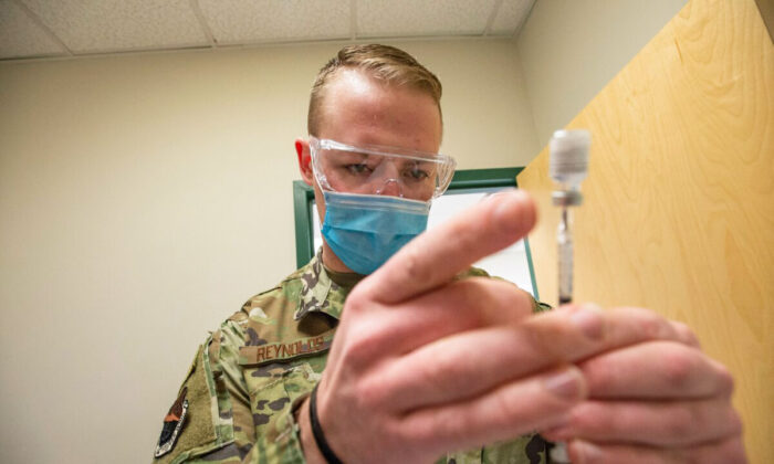 Un sargento de la Fuerza Aérea de EE. UU. manipula una vacuna contra la COVID-19 de Pfizer en una clínica de Massachusetts el 16 de febrero de 2021. (Joseph Prezioso/AFP vía Getty Images)