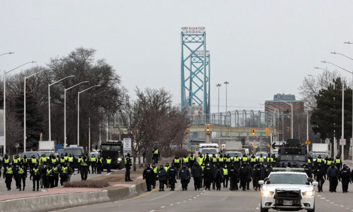 La policía detiene a unos manifestantes cerca del puente Ambassador en Windsor, Canadá, el 13 de febrero de 2022. (Jeff Kowalsky/AFP vía Getty Images)