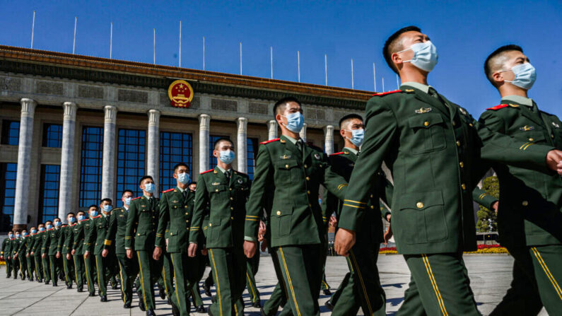 Soldados chinos del Ejército Popular de Liberación llevan mascarillas mientras marchan después de una ceremonia que marca el 70º aniversario de la entrada de China en la Guerra de Corea, en el Gran Salón del Pueblo en Beijing, China, el 23 de octubre de 2020. (Kevin Frayer/Getty Images)