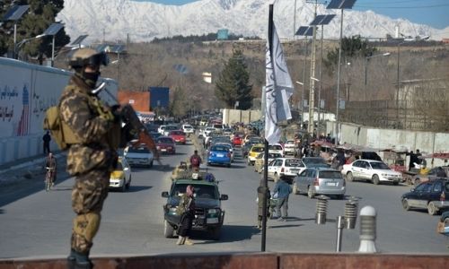 Combatientes talibanes montan guardia antes de iniciar una protesta de mujeres en apoyo del régimen talibán en la plaza Ahmad Shah Massoud, frente a la embajada estadounidense en Kabul, el 26 de enero de 2022. (WAKIL KOHSAR/AFP vía Getty Images)
