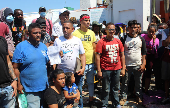 Migrantes centroamericanos se cosen la boca mientras participan en una manifestación hoy, en la ciudad de Tapachula, en el estado de Chiapas, México. EFE/Juan Manuel Blanco