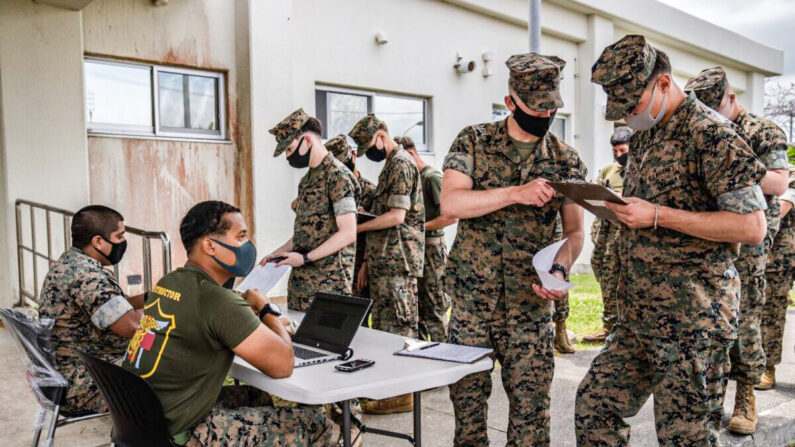 Marines de Estados Unidos registran sus datos mientras hacen fila para recibir la vacuna de Moderna contra el coronavirus, en Camp Hansen, el 28 de abril de 2021, en Kin, Japón. (Carl Court/Getty Images)