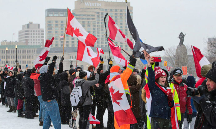 Miles de manifestantes se reunieron ante el Parliamento en Ottawa,  Canadá, y cantaron "O Canada", el 12 de febrero de 2022. (Richard Moore/The Epoch Times)
