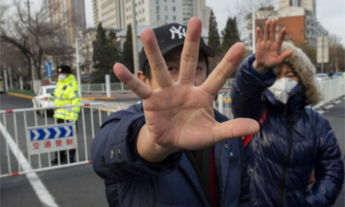 Oficiales de policía vestidos de civil hacen un gesto para impedir que se tomen fotografías frente al Tribunal Popular Intermedio No. 2 de la ciudad de Tianjin, el 26 de diciembre de 2018, donde comenzó el juicio al abogado de derechos humanos, Wang Quanzhang. (Nicolas AsfourI/AFP/Getty Images)
